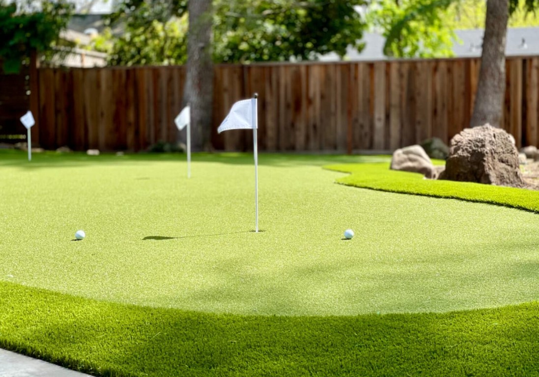 Professional backyard putting green installation with flags and golf balls in St. Charles, MO